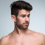 Mann wählt zwischen Nassrasierer und Rasierapparat.